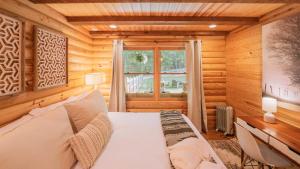 a bedroom with a bed and a desk and a window at Amenity Packed A-frame Cabin With Two Bedrooms And Loft in Gainesville