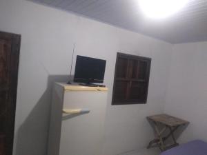 a room with a tv on top of a wall at Pousada Plataforma in Tramandaí