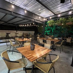 a restaurant with wooden tables and chairs and plants at HOTEL 9.5 SAN FERNANDO in Cali