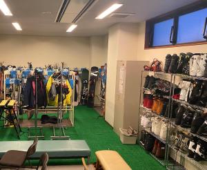 a store with a room filled with clothes and shoes at Ougiya Ryokan in Hakuba