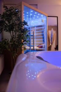 a bath tub in a room with a large window at Spa Palawan privé avec jacuzzi et sauna Liège in Liège