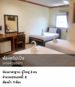 a room with two beds and a desk and a mirror at Golden Bee PhiPhi in Phi Phi Islands