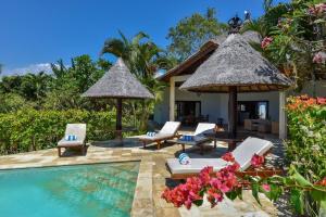 um resort com uma piscina com cadeiras e guarda-sóis em Villa Lumba-Lumba1 em Umeanyar