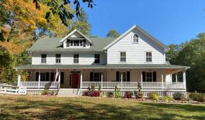een wit huis met een vlag in de voortuin bij Howland House in Mount Tremper