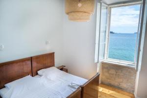 a bedroom with a bed and a large window at Villa Beachfront in Orebić