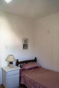 1 dormitorio con 1 cama y 1 mesa con lámpara en Departamento NAMIVA II en Córdoba