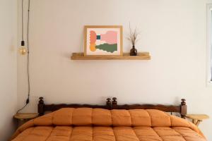 a bed in a bedroom with a picture on the wall at Departamento NAMIVA II in Córdoba