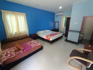 珍南海灘的住宿－Drym Valley Langkawi，一间卧室设有两张床和蓝色的墙壁