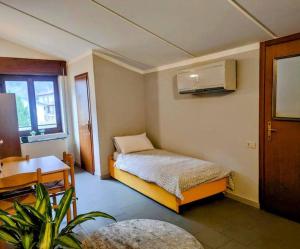 a small bedroom with a bed and a desk at Lake and Mountain Suits in Verceia