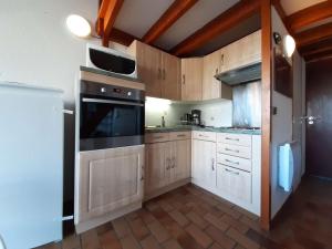 a kitchen with wooden cabinets and a stove top oven at Appartement T2 pour 6 avec balcon et équipements complets, proche navette à Piau-Engaly - FR-1-457-314 in Aragnouet