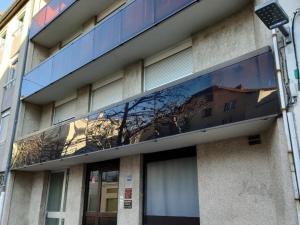 un edificio con un reflejo de un árbol en la ventana en Appartement Saint-Chamond, 2 pièces, 2 personnes - FR-1-496-271, en Saint-Chamond