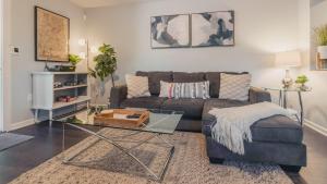 ein Wohnzimmer mit einer Couch und einem Glastisch in der Unterkunft Hip Duplex Near UAB Perfect For Groups in Birmingham