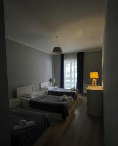 1 Schlafzimmer mit 2 Betten, einer Lampe und einem Fenster in der Unterkunft Hotel White Mountains • თეთრი მთები in Mestia