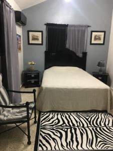 a bedroom with a zebra print bed and a chair at Hacienda de Flores in Guayacanes +22 photos