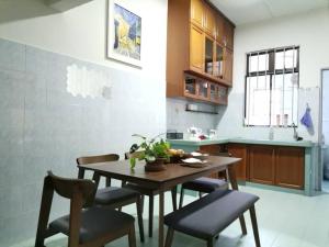 a kitchen with a wooden table and some chairs at UIA Younee Kuantan Homestay 3R2B 9pax 5 min to town in Kuantan