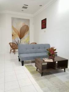 a living room with a blue couch and a coffee table at UIA Younee Kuantan Homestay 3R2B 9pax 5 min to town in Kuantan