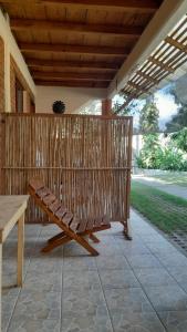 eine Holzbank auf einer Terrasse mit einem Holzdach in der Unterkunft Casa Aldairis in Mazunte