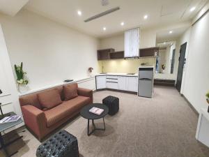 a living room with a couch and a kitchen at Grace Hotel Dunbei in Taipei