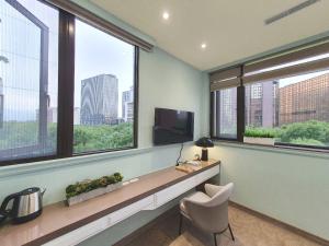 een kantoor met ramen, een bureau en een televisie bij Grace Hotel Dunbei in Taipei