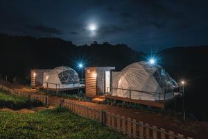 dois alojamentos de luxo yurt à noite com a lua em Dome บ้านสกายพฤกษ์ em Mon Jam