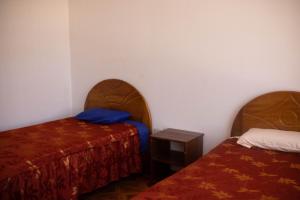 Habitación con 2 camas y una mesa pequeña. en Hinkiori Inn - Hotel Manu, en Pillcopata