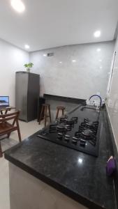 cocina con encimera negra y fogones en Apartamento Maresia en Morro de São Paulo