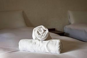 a white towel sitting on top of a bed at Hakuba Matata Apartment in Hakuba