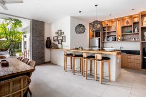 a kitchen with a island with bar stools at Villa GoodFellas by BaliSuperHost in Seminyak