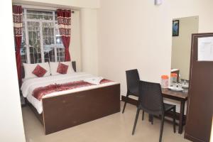 a bedroom with a bed and a table and chairs at White Rabbit Guest House in Shillong +16 photos