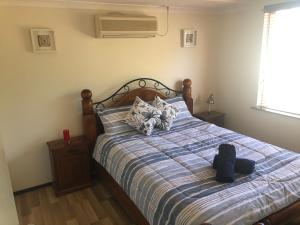 um quarto com uma cama com um edredão azul e branco em Superior Reef to Range em Exmouth