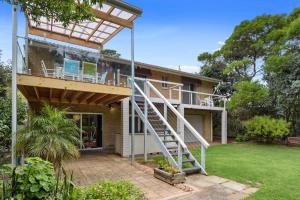 a house with a deck and a staircase on it at Broadbeach Retreat 32 Broadbeach Drive in Carrickalinga