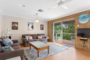 a living room with a couch and a tv at Broadbeach Retreat 32 Broadbeach Drive in Carrickalinga