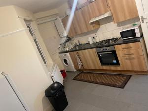 a small kitchen with a stove and a refrigerator at Welcome to your new home. in Redbridge