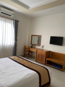 a hotel room with a bed and a television at BĂNG BOUTIQUE HOTEL in Thu Dau Mot