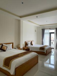 a hotel room with two beds and a window at BĂNG BOUTIQUE HOTEL in Thu Dau Mot +32 photos