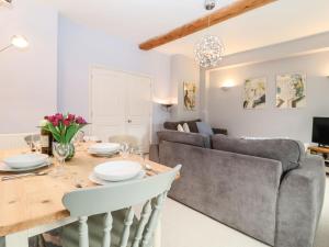 a kitchen and living room with a table and a couch at Saffron, Blythview in Blythburgh