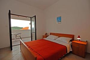 Schlafzimmer mit einem Bett und einer Glasschiebetür in der Unterkunft Apartments Denko - with pool in Kali