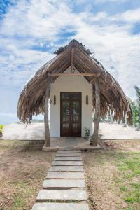 a small white building with a thatched roof at Eagle View villa in Ella