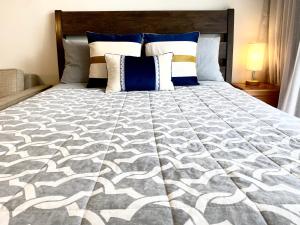 a large bed with a gray and white comforter at Free parking Comfy central Waikiki in Honolulu +12 photos