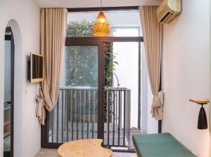 a living room with a door to a balcony at the second home of yours in Hanoi