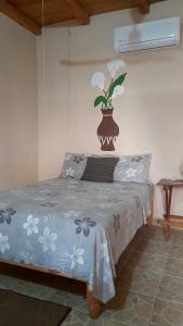 een slaapkamer met een bed met een bloemvaas aan de muur bij Casa Aldairis in Mazunte