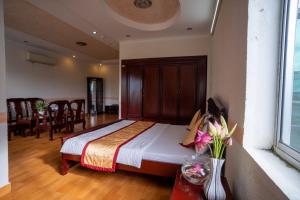 1 dormitorio con 1 cama y comedor en Khách Sạn Bông Sen en Vị Thanh