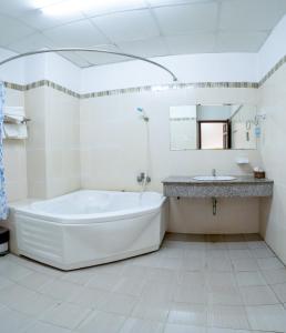a white bathroom with a tub and a sink at Khách Sạn Bông Sen in Vị Thanh