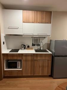 a kitchen with wooden cabinets and a stainless steel refrigerator at Seaside vacation in Rawai Beach