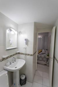 Baño blanco con lavabo y espejo en Local Experience in SMDT - cerca de Casa Historica en San Miguel de Tucumán