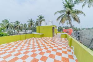 d'un balcon avec un sol en damier et des palmiers. dans l'établissement Ameer Homes, à Pondichéry