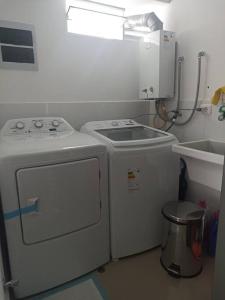 een keuken met een wasmachine en een wastafel bij MWhite'sHome in Lima