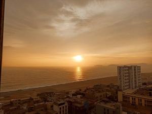 un tramonto sull'oceano con una città e la spiaggia di MWhite'sHome a Lima