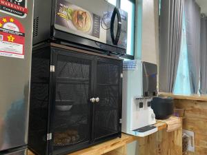 a microwave sitting on top of a black cabinet at TERATAK QASEH Meru in Kapar