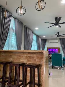 a bar in a living room with two stools at TERATAK QASEH Meru in Kapar